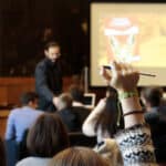 una studentessa alza la mano durante un incontro di Bookcity